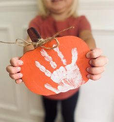 "These 6\" wide pumpkins come painted orange with a brown stem and wrapped in jute and ready for your child's handprint with the included white paint." Wooden Pumpkin Crafts For Kids, Paper Pumpkin Craft Preschool, Fall Harvest Preschool Crafts, Purple Toddler Crafts, Halloween For Preschoolers, Prek Halloween Crafts, Pumpkin Art Preschool, Fall Daycare Crafts, Pumpkin Diy Crafts