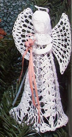 a crocheted angel ornament hanging from a christmas tree