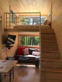 a living room with stairs leading up to the loft