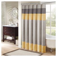 a bathroom with a bathtub, sink and shower curtain in grey and yellow colors