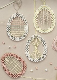 four pieces of string art on a table with thread spools and other crafting supplies