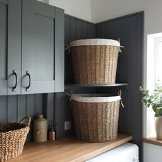 two baskets are sitting on top of the washer and dryer in this laundry room