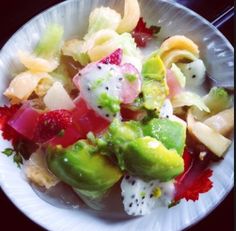 a white bowl filled with lots of different types of food on top of a table