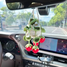 the interior of a car is decorated with crochet and stuffed cherries hanging from hooks