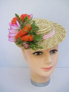 "* A cute mini boater hat has been trimmed out with Easter in mind. Hot pink and vibrant orange flowers complement the carrots off to the side making it a fun and festive hat to wear to any Easter event. * Designed on a 8.0\" diameter round straw hat with an elastic band on the inside. * Designed to look airy and light it would be perfect for a ladies luncheon, charity event or fashion show. * Fun to wear to any Easter Festival or Parade, Egg Hunt, Easter Dinner, Tea or Garden Party, Derby Event Fitted Boater Hat For Spring Garden Party, Orange Brimmed Spring Hat, Orange Short Brim Hat For Spring, Whimsical Flower-shaped Mini Hats For Garden Party, Fitted Orange Mini Hats For Summer, Retro Spring Mini Hats With Short Brim, Retro Mini Hats With Short Brim For Spring, Retro Short Brim Mini Hats For Spring, Retro Mini Hat With Short Brim For Spring