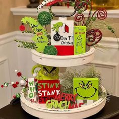 three tiered tray with christmas cards and decorations on the top, in front of a fireplace