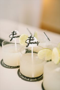 three candles with lemon slices on them sitting next to each other in front of a white table