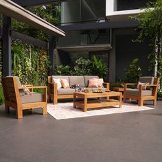 an outdoor living area with wooden furniture and plants