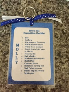 a blue and white tag with instructions for the competition checklist on it's side