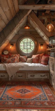 an attic bedroom with a bed, window and rug on the floor in front of it