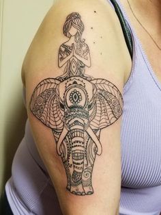 an elephant with a woman sitting on top of it's head tattooing her arm