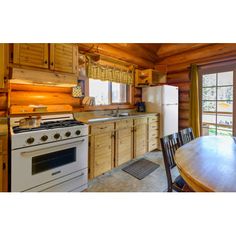 a kitchen with an oven, table and chairs