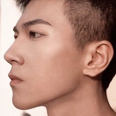 a close up of a person with a short haircut and an undercut on his face