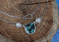 This necklace features a stunning and rare piece of Blue Diamond Turquoise that’s full of a deep teal and bold, painterly black markings - it definitely packs a punch! The stone is adorned with one of my favorite elements, hand stamped puffy diamonds. The silver is oxidized to bring out all the fine details and depth and is topped off with a brushed finish. The pendant hangs on a 17’’ sterling silver paperclip chain with a handmade clasp. The chain has been darkened to match the patina on the pe Turquoise Chrysocolla Necklace With Patina, Artisan Necklace With Large Chrysocolla Pendant, Handmade Pendant Necklace, Deep Teal, Handmade Pendant, Blue Diamond, Handmade Pendants, Paper Clip, Chain Lengths