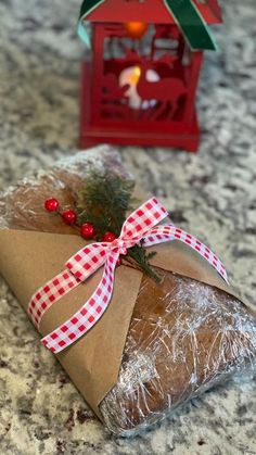 a piece of bread wrapped in brown paper and tied with a red checkered ribbon