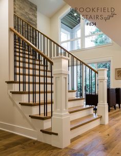 a stair case in a house with wood floors and white railings on both sides