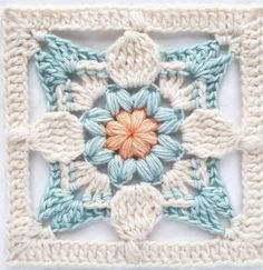 a crocheted square with an orange flower in the center and two rows of smaller squares on each side