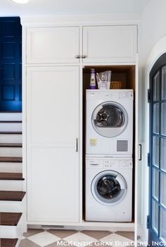 a washer and dryer in a room with stairs leading up to the second floor