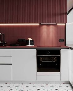 a kitchen with white cabinets and pink walls