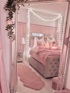 a bedroom with a large mirror on the wall and pink bedding in front of it