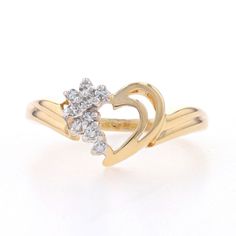 a yellow gold ring with two hearts in the middle and three diamonds on each side