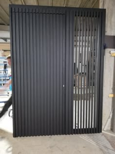 an open metal door in the middle of a parking garage with bars on it's sides