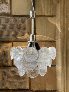 a glass chandelier hanging from a brick wall