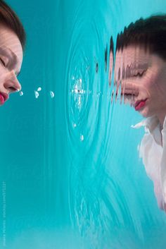 two women are looking at each other in the water with their faces close to one another