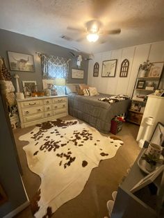 a bedroom with two beds, dressers and a cow hide rug on the floor