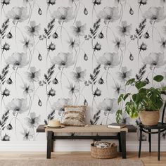 a bench in front of a floral wallpaper with black and white flowers on it