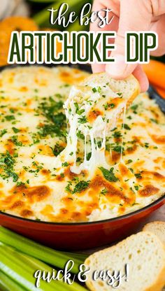 the best artichoke dip in a red bowl with bread and celery