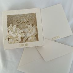 three white envelopes with gold foil designs on the front and back of them, sitting next to each other