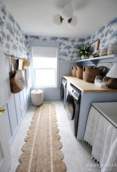 a washer and dryer in a small room with floral wallpaper on the walls