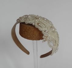 Bridal ivory satin (polyester) headband - a variety of different pearls, beads, sequins and embroidery threads have been used to create a well proportioned diamond shaped motif measuring 20 cm long and 8.5 cm wide.   Can also be made with plain birdcage veil (add £8 to price) or birdcage veil with scattered pearl (add £10 to price). Postage & packaging fee includes elegant hat box. As each hat is made individually to order it is not possible for me to take returns.  Do get in touch if you have any questions. Matching  sash/belt available (see my shop) Silver Embellished Headpiece For Wedding, Silver Embellished Wedding Headpiece, Adjustable Beaded Bridal Belt For Wedding, Elegant Lace Hair Accessories With Adjustable Fit, Elegant Lace Hair Accessories With Matching Headband, Elegant Adjustable Lace Headband, Elegant Lace Adjustable Headband, Handmade Fitted Wedding Headpieces, White Lace Headband For Party