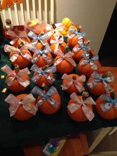 many pumpkins with bows on them sitting on a table in front of a child's chair