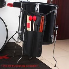 a drum case with sticks and drumsticks in it next to a set of drums