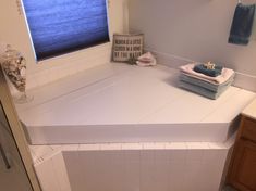 a white counter top in a bathroom next to a window