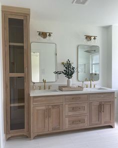 a bathroom with double sinks and wooden cabinets