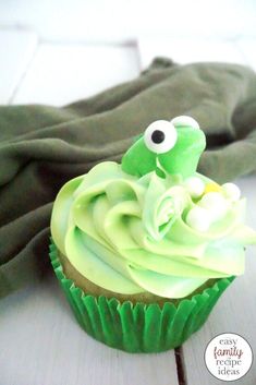 a cupcake with green frosting and googly eyes