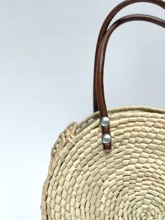 Sustainably Handwoven Straw Circle Bag The Mia Straw Circle Bag is lightweight and durable. This small-size bag will hold all of your essential items. It's the perfect bag for cruising around town. These bags are individually hand-woven with sustainable palm leaves and have naturally tanned leather handles. Thoughtfully designed and ethically made by artisans in Guerrero, Mexico, in a fair trade environment. Each bag is unique and may vary in size, and color, and may have small imperfections. De Natural Palm Leaf Bags With Braided Handles, Natural Palm Leaf Beach Bag For Travel, Summer Woven Leather Bag With Round Handle, Eco-friendly Bags With Bamboo Handle, Natural Basket-shaped Palm Leaf Bag, Eco-friendly Woven Leather Beach Bag, Woven Palm Leaf Bag For Travel, Palm Leaf Travel Tote, Eco-friendly Natural Fiber Bag With Bamboo Handle