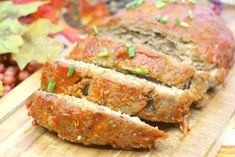 sliced meatloaf sitting on top of a wooden cutting board