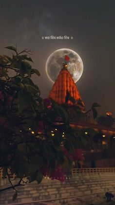 the full moon is seen behind a building with a spire on it's roof