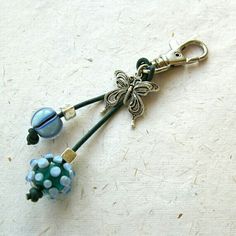 a keychain with beads and flowers attached to it on a white tablecloth