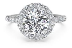 a round cut diamond ring with halos and pave set shoulders