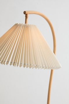 a wooden table lamp with a white paper shade on it's head and arm