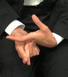 a man in a suit making the vulcan sign with his hands