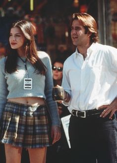 a man standing next to a woman in front of a store window with tapers on it