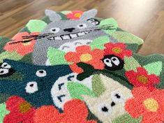 two rugs on the floor are decorated with cartoon cats and flowers, one has a cat's face