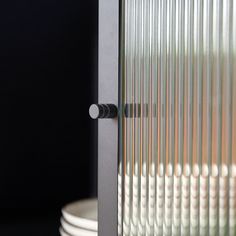 a close up of a metal door on a black surface with white plates in the background