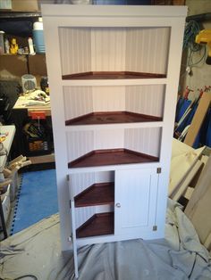 a white cabinet with shelves on top of it